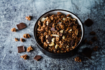 Chocolate nuts oatmeal granola with chocolate slices in a bowl