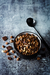 Chocolate nuts oatmeal granola with chocolate slices in a bowl