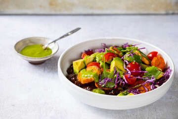 Vegan bowl with black beans, roast sweet potatoes, red cabbage and avocado