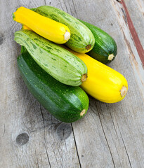 Zucchini on wooden background. Yellow and green zucchini.