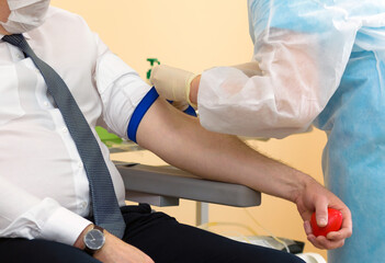 Blood donor at donation with a bouncy ball holding in hand.