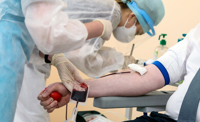 Blood donor at donation with a bouncy ball holding in hand.
