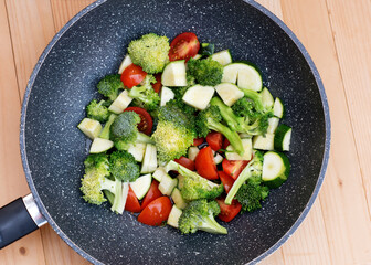 Green vegetables, broccoli, zucchini, tomatoes in a WOC pan 