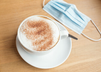 cup of coffee  and face mask on the table