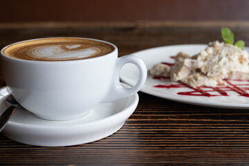 a white ceramic cup of cappucino as a coffee break concept