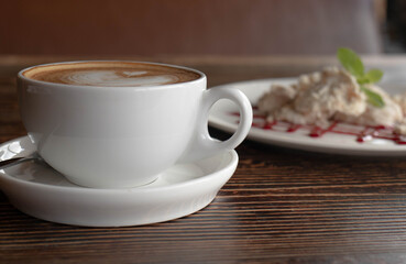 a white ceramic cup of cappucino as a coffee break concept