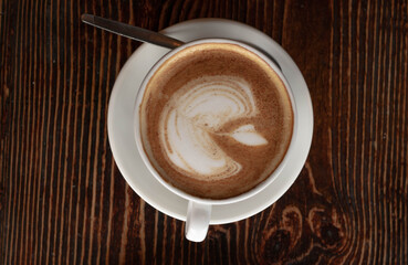 a white ceramic cup of cappucino as a coffee break concept