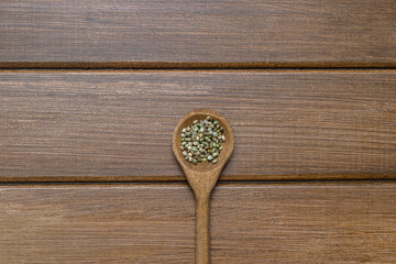 Hemp seeds, wooden spoon on wooden background. Alternative medicine. Vegetarian food concept. Natural product .Marijuana alternative herbal medicine concept.