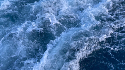 Naklejka na ściany i meble Seawater Ocean surface, sea foam on the blue ocean, background.