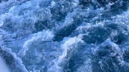 Fototapeta na wymiar Seawater Ocean surface, sea foam on the blue ocean, background.