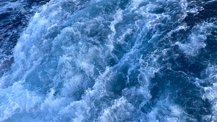 Fototapeta na wymiar Seawater Ocean surface, sea foam on the blue ocean, background.