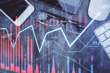 Multi exposure of forex graph hologram over desktop with phone. Top view. Mobile trade platform concept.