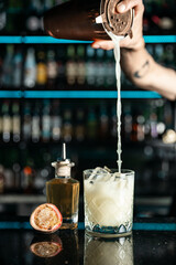 Expert barman is making cocktail at night club