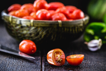 small red tomato used as a culinary ingredient in rustic cuisine, sliced ​​and diced tomatoes