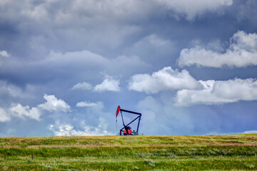 Oil derricks amidst canola fields alongside the highway outside of Drumheller Alberta