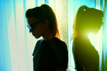 Close-up of a young caucasian CIA woman in black sun goggles standing in a room near blue curtains. Istanbul, Turkey. - obrazy, fototapety, plakaty