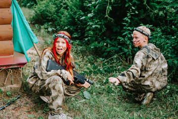 Children in camouflage ready to play in laser tag shooting game with a weapon outdoor