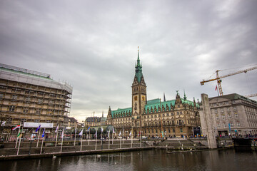 Obraz premium Lake Binnenalster in Altstadt quarter and at the background the famous Hamburg town hall with dramatic clouds at market square Hamburg, Germany.