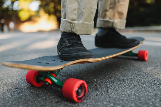 Longboard with red wheels on the asphalt.