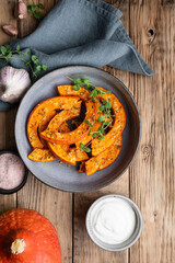 Roasted Hokkaido pumpkin slices topped with olive oil, grated garlic and herbs, served with sour cream