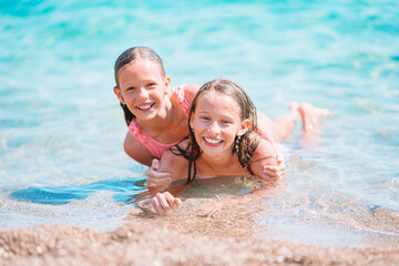 Adorable little girls having fun on the beach