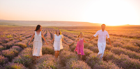 Family in lavender flowers field at sunset