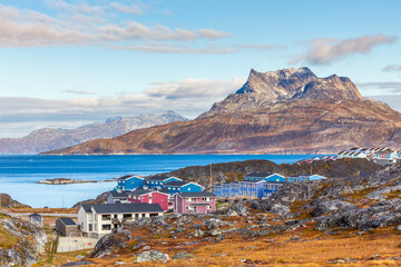 Inuit houses and cottages scattered across tundra landscape in residential suburb of Nuuk city with...