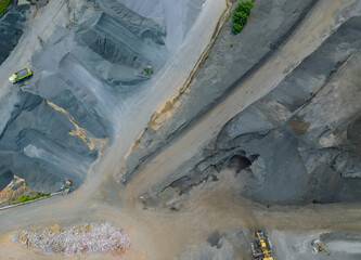 Aerial of asphalt and cement factory large piles of construction rocks used for asphalt production...