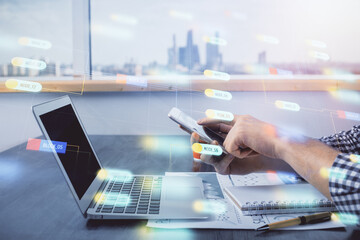 Double exposure of man's hand holding and using a digital device and data theme hologram drawing. Technology concept.