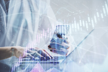 Double exposure of financial graph sketch hologram and woman holding and using a mobile device....