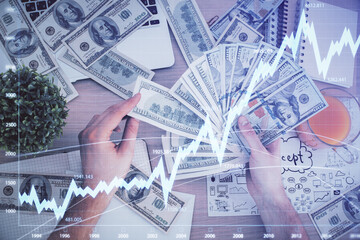 Multi exposure of financial graph drawing hologram and USA dollars bills and man hands. Analysis concept.