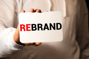 Businessman holding a card with text REBRAND