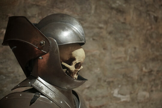 human Skull in a knight helmet on a gray background