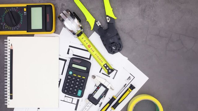 Architecture plans and construction tools appear on table, Stop motion 
