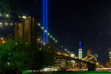 Fototapeta na wymiar The twin lights from the world trade center with the Brooklyn Bridge in front, illuminated each September 11 