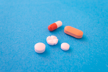 Macro of Different kind of pills and capsules against a blue background
