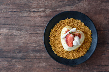 Single serving of heart shaped creamy Italian cheesecake on graham cracker crumbles
