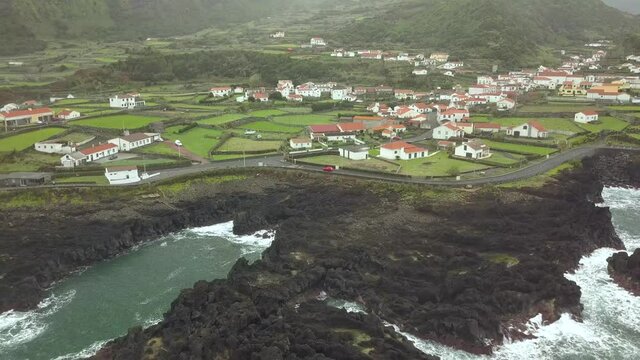 Reverse Aerial Beautiful Countryside Town On Coastline, Faja Grande, Azores