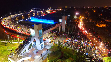 Aerial view of nighttime fountain attraction at Surabaya bridge, East Java, Indonesia which...