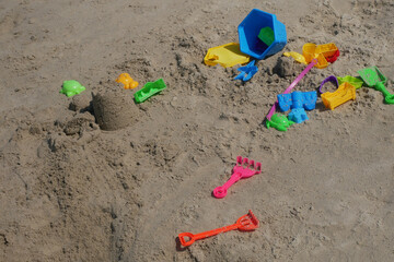 Some beach toys are made of plastic scattered randomly on the beach sand. Abandoned by children.
