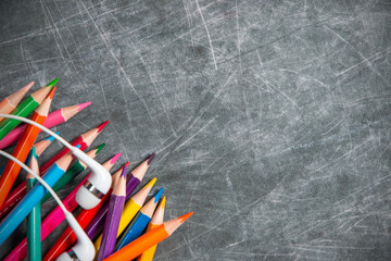 multicolored school supplies lie on black chalkboard, short focus, partial blur