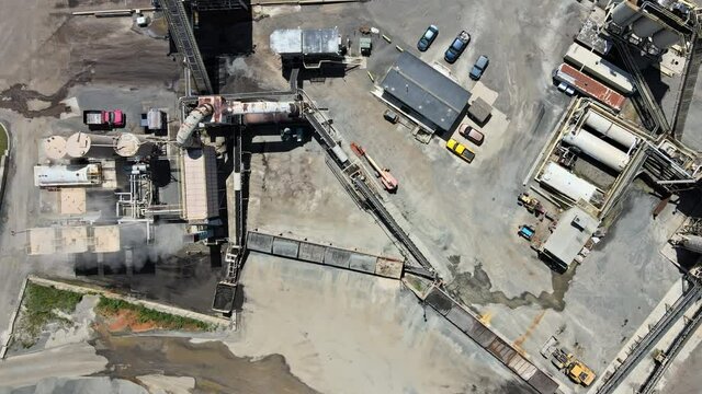 Aerial shot of asphalt and cement factory large piles of construction rocks used for asphalt production heavy machinery ready to work