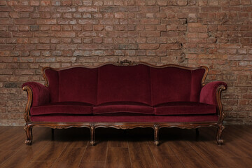 Red sofa in the room. Brick wall.