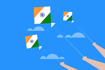 Hand holding Kites with Indian flag colours flying in the sky