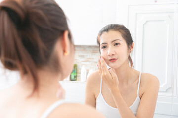 Obraz na płótnie Canvas Asian Beauty Woman apply face cream in bathroom.