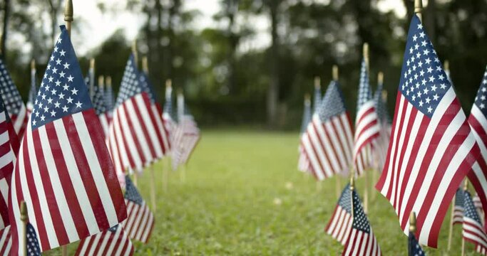 Rows of slow waving US American flags blowing in the wind. Patriotic concept for USA holidays, 4th of July, Memorial day, or Veteran's day.