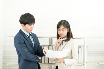 Fototapeta premium Asian business people having a casual discussion. Staff standing and discussing work in office.