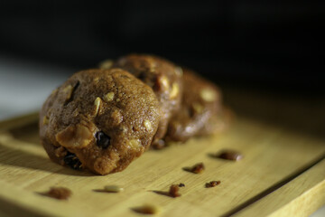 Homemade sweet chocolate cookies on wooden table with black background