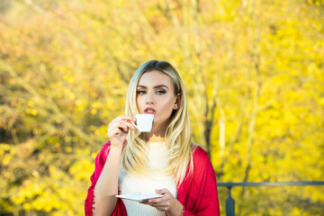 Fototapeta premium Autumn woman drink coffee. Fall leaves and cup of coffee. Seasonal, morning coffee.