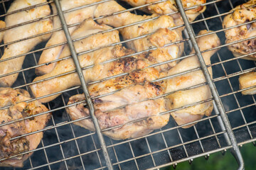 Chicken meat grilling on the brazier. Selective focus.